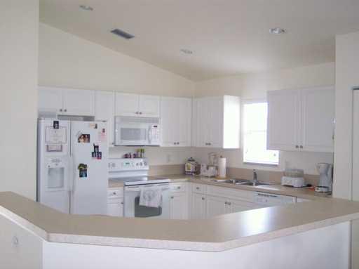 2434 Southwest Malibu Way Stuart, FL 34997 - Photo 2 of 8 a kitchen with stainless steel appliances granite countertop a sink stove and refrigerator
