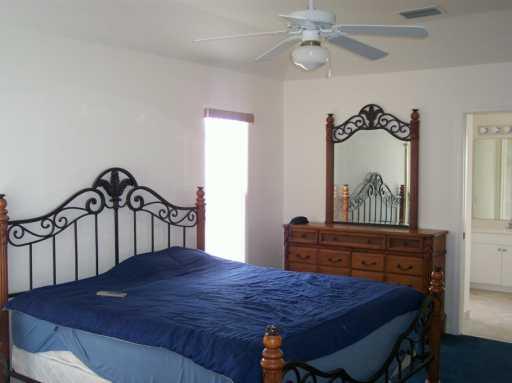 2434 Southwest Malibu Way Stuart, FL 34997 - Photo 5 of 8 a bedroom with a bed table and chair