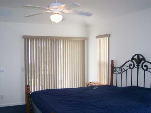 2434 Southwest Malibu Way Stuart, FL 34997 - Photo 6 of 8 a bedroom with a bed and a chandelier
