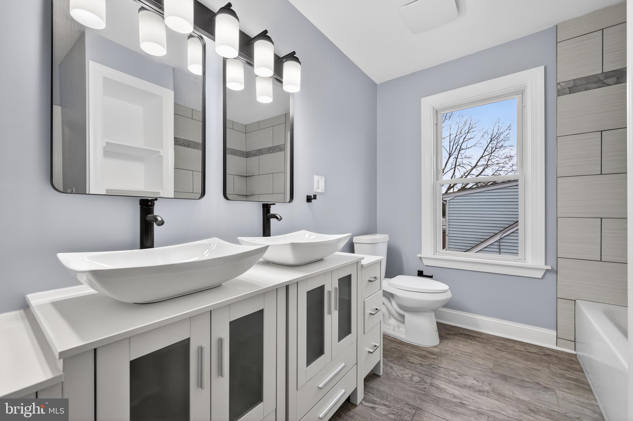 312 West Monroe Avenue Magnolia, NJ 08049 - Photo 18 of 43 a spacious bathroom with a toilet a sink a mirror and a window