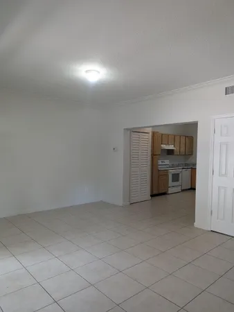 a view of an empty room with a kitchen