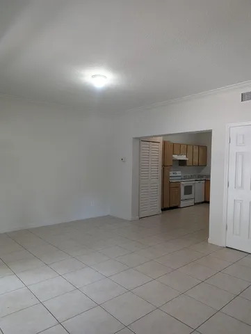 a view of an empty room with a kitchen