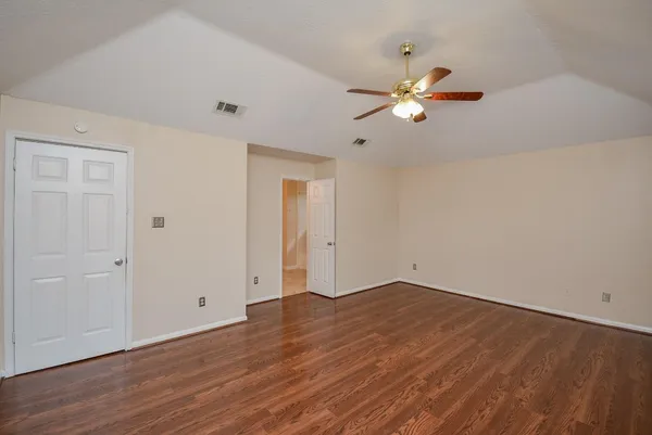 a view of empty room with wooden floor