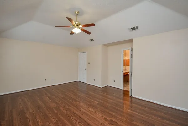 a view of an empty room with wooden floor