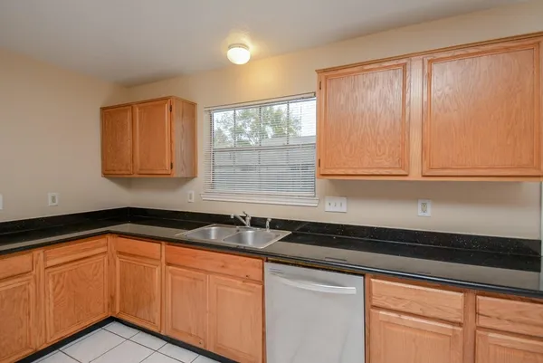 a kitchen with granite countertop cabinets sink and window
