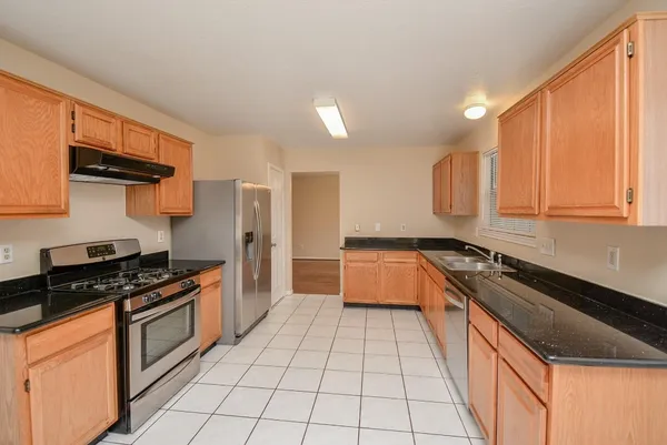 a kitchen with stainless steel appliances granite countertop a stove a sink and a microwave