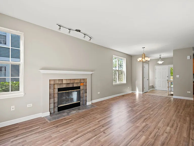 2568 Golf Ridge Circle, Unit 2568 Naperville, IL 60563 - Photo 4 of 18 an empty room with windows and a fireplace