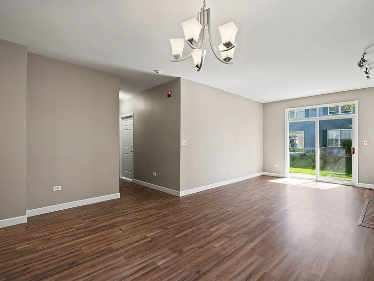 2568 Golf Ridge Circle, Unit 2568 Naperville, IL 60563 - Photo 6 of 18 a view of an empty room with wooden floor and windows
