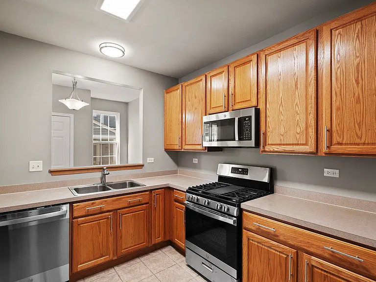 2568 Golf Ridge Circle, Unit 2568 Naperville, IL 60563 - Photo 7 of 18 a kitchen with stainless steel appliances granite countertop a stove a sink and a microwave