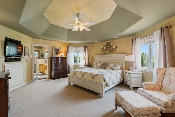 a spacious bedroom with bed and a flat screen tv