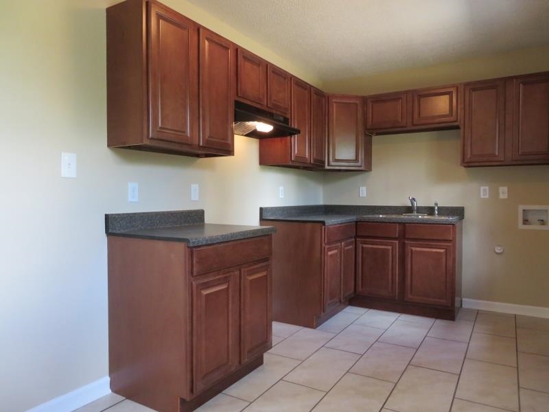 364 Elder Road Memphis, TN 38109 - Photo 5 of 11 a kitchen with stainless steel appliances granite countertop wooden cabinets a stove top oven a sink and dishwasher
