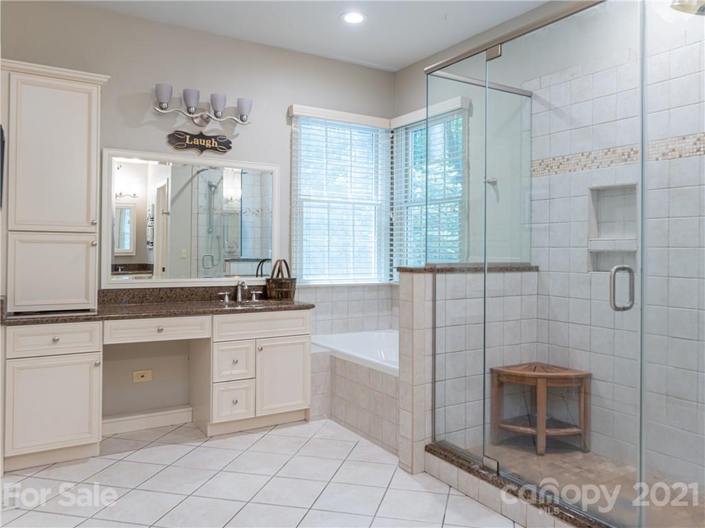103 Windsong Drive Fairview, NC 28730 - Photo 15 of 36 a bathroom with a double vanity sink a mirror and a bathtub