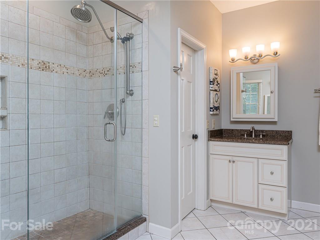 103 Windsong Drive Fairview, NC 28730 - Photo 16 of 36 a bathroom with a shower sink and mirror