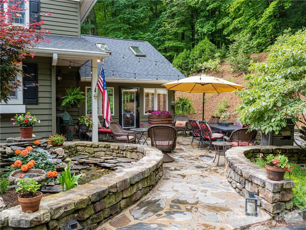 103 Windsong Drive Fairview, NC 28730 - Photo 3 of 36 a view of a patio with table and chairs under an umbrella