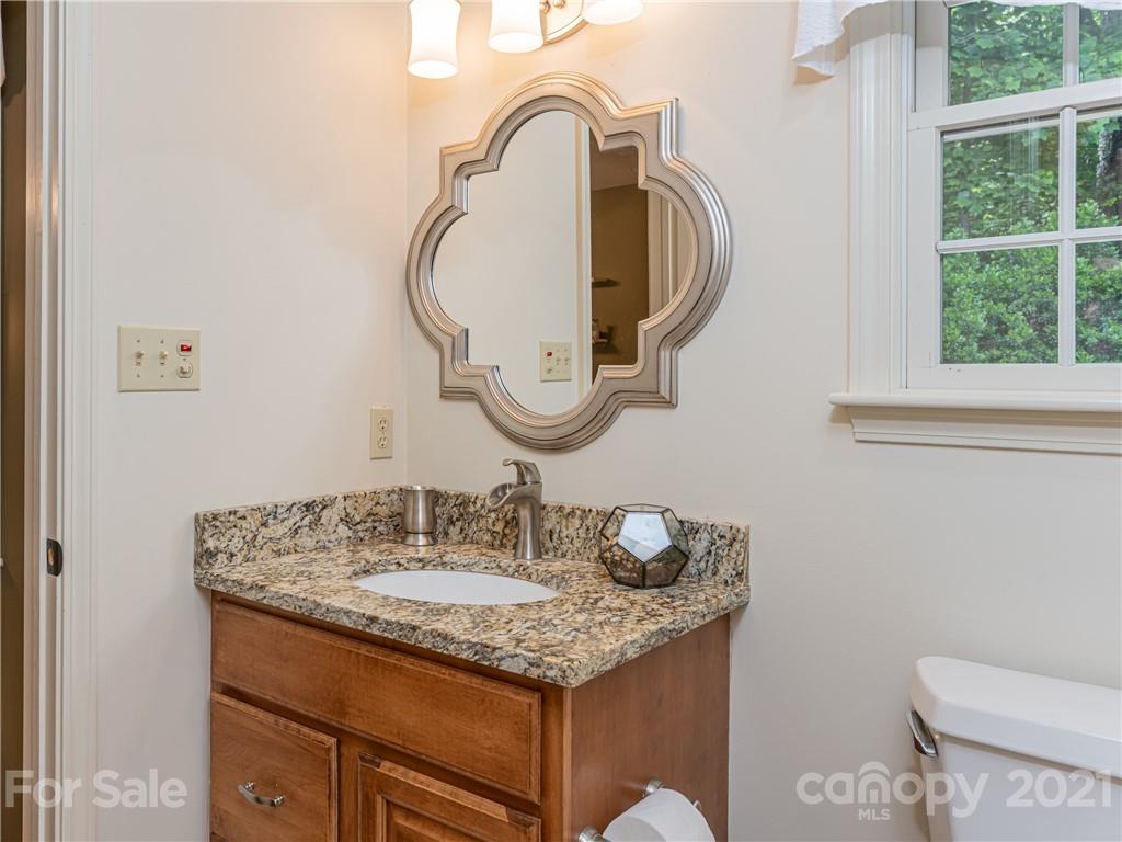 103 Windsong Drive Fairview, NC 28730 - Photo 21 of 36 a bathroom with a granite countertop toilet a sink and a mirror