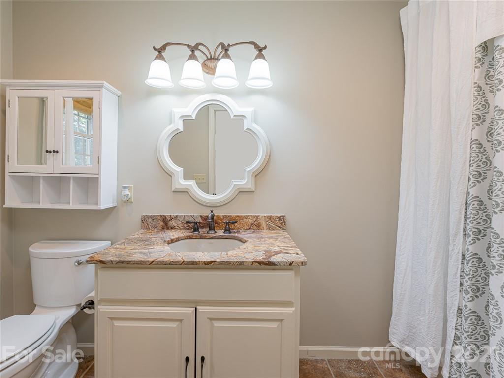 103 Windsong Drive Fairview, NC 28730 - Photo 25 of 36 a bathroom with a granite countertop sink and a mirror