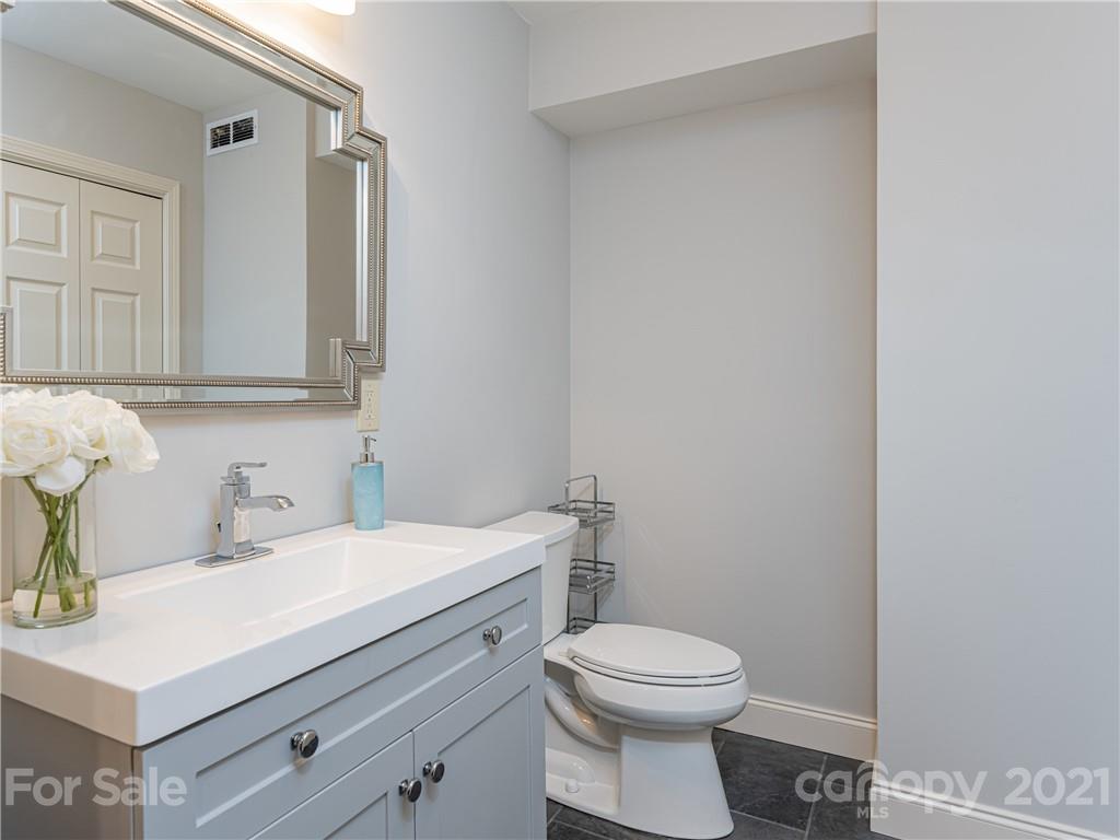 103 Windsong Drive Fairview, NC 28730 - Photo 28 of 36 a bathroom with a sink a toilet and mirror