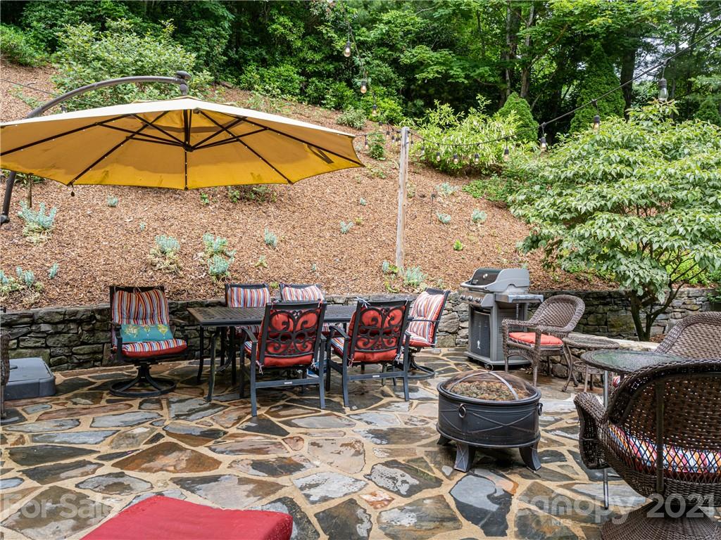 103 Windsong Drive Fairview, NC 28730 - Photo 4 of 36 an outdoor space with furniture and umbrella