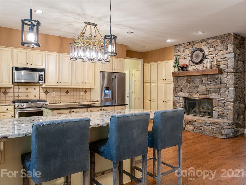 103 Windsong Drive Fairview, NC 28730 - Photo 9 of 36 a kitchen with stainless steel appliances granite countertop a stove top oven a refrigerator a sink and a chairs