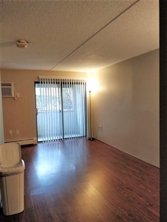 159 Franklin Street, Unit A3 Stoneham, MA 02180 - Photo 2 of 5 an empty room with wooden floor and windows