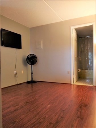 159 Franklin Street, Unit A3 Stoneham, MA 02180 - Photo 3 of 5 a view of an empty room with a window and wooden floor