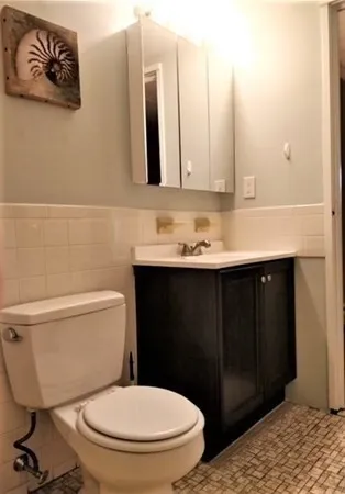 a bathroom with a toilet a sink and mirror