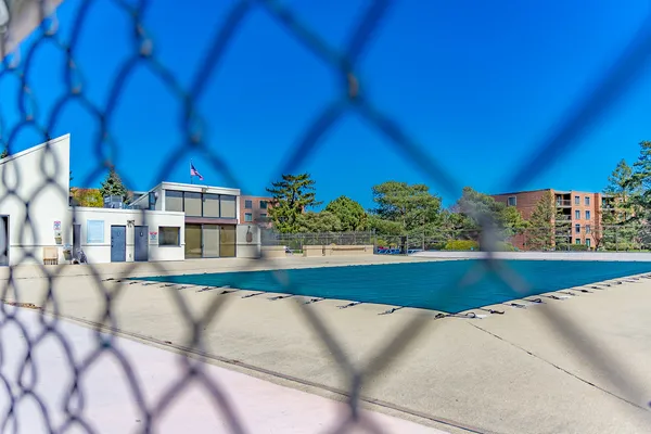 a view of a swimming pool with a lawn chairs under an umbrella