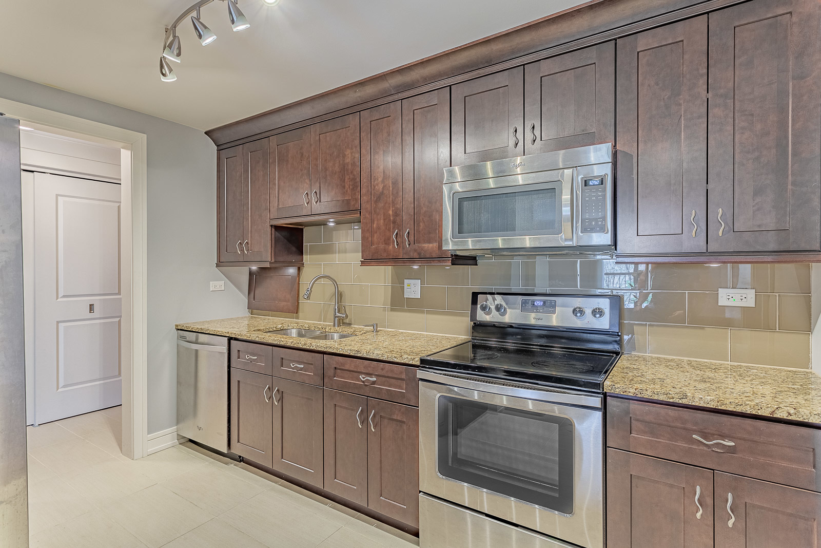 1615 East Central Road, Unit 401A Arlington Heights, IL 60005 - Photo 6 of 18 a kitchen with granite countertop cabinets stainless steel appliances and a counter space