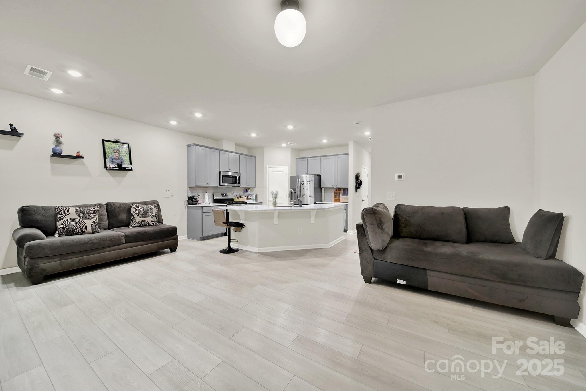 6009 Chelsea Oaks Ridge Fort Mill, SC 29708 - Photo 12 of 30 a living room with furniture and a dining table with kitchen view
