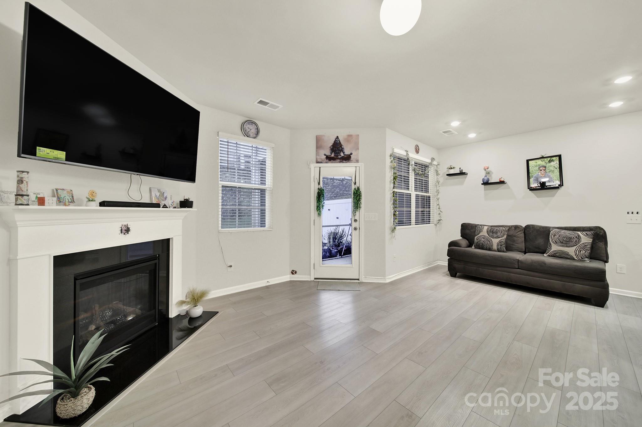 6009 Chelsea Oaks Ridge Fort Mill, SC 29708 - Photo 13 of 30 a living room with furniture a flat screen tv and a fireplace