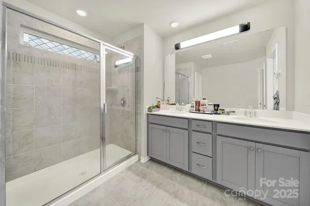 a bathroom with a double vanity sink mirror and shower