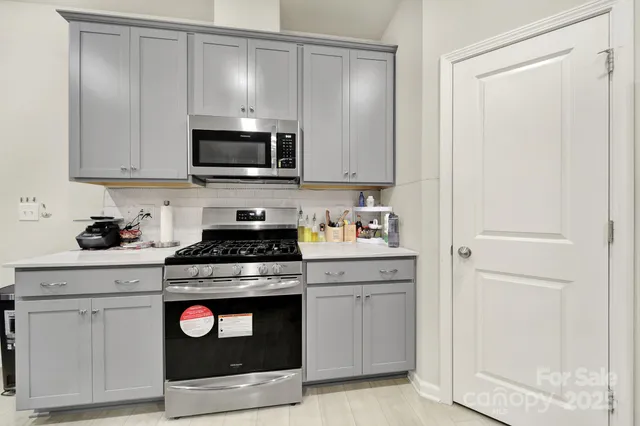 a kitchen with white cabinets and stainless steel appliances