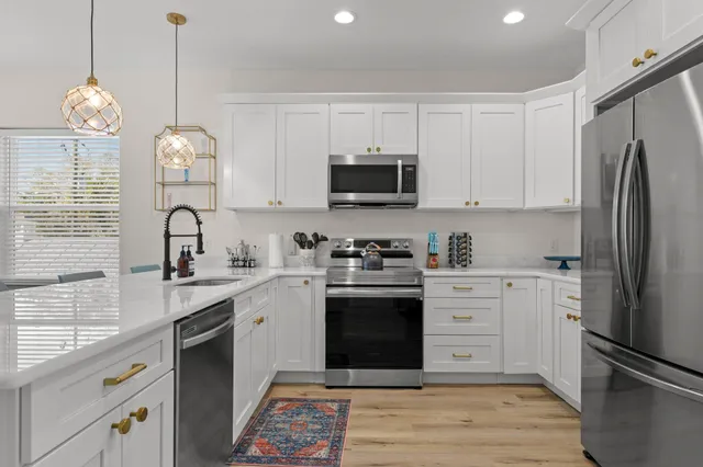 a kitchen with white cabinets and stainless steel appliances