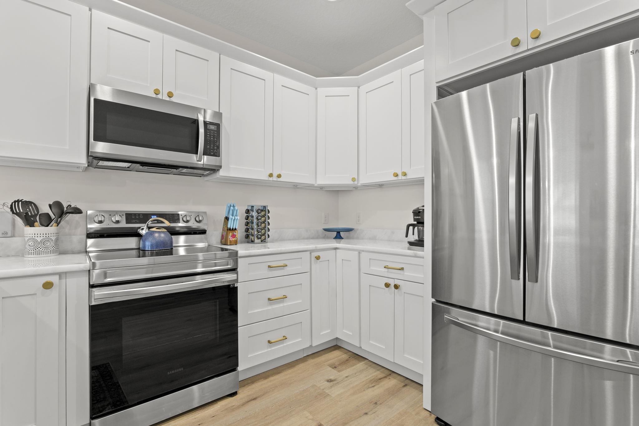 110 Moore Street St. Augustine, FL 32084 - Photo 7 of 39 a kitchen with white cabinets and stainless steel appliances