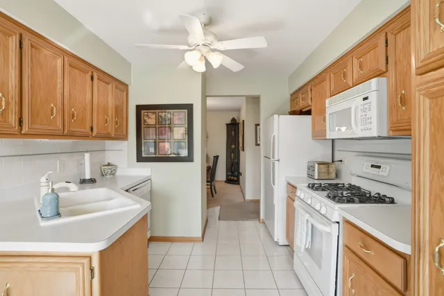 a kitchen with a sink dishwasher a refrigerator a stove and white cabinets with wooden floor