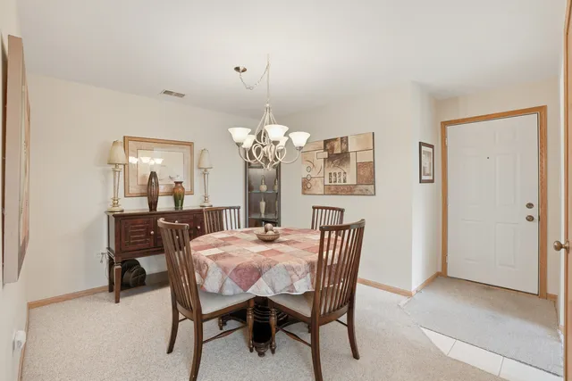 a view of a dining room with furniture and a chandelier