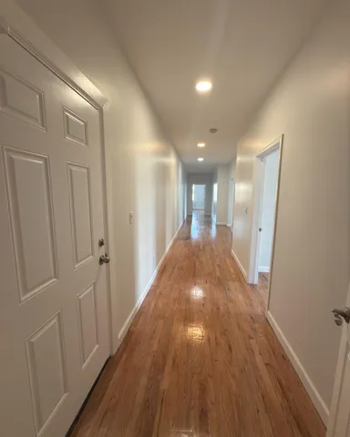 a view of a hallway with wooden floor