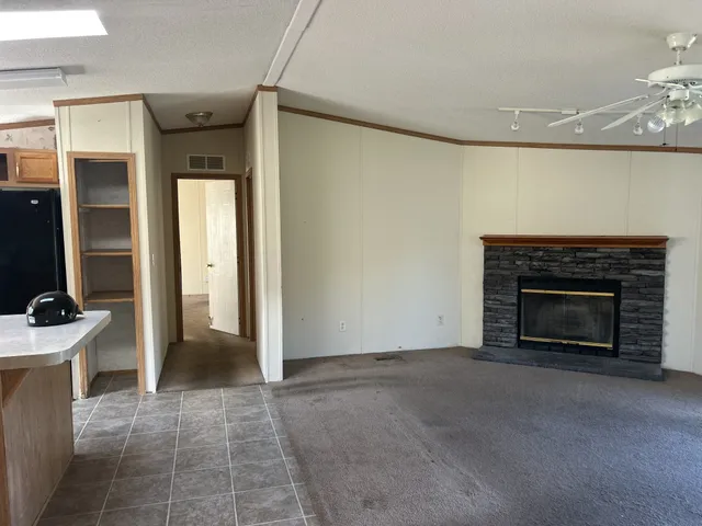 a view of an empty room with a fireplace and a window