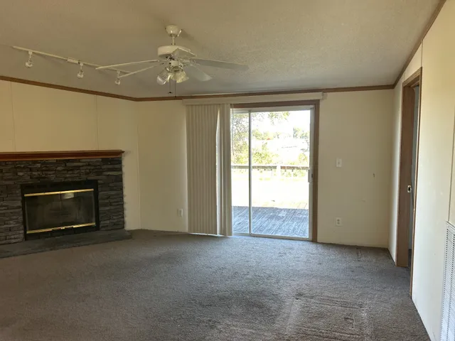 a view of an empty room with window and closet area