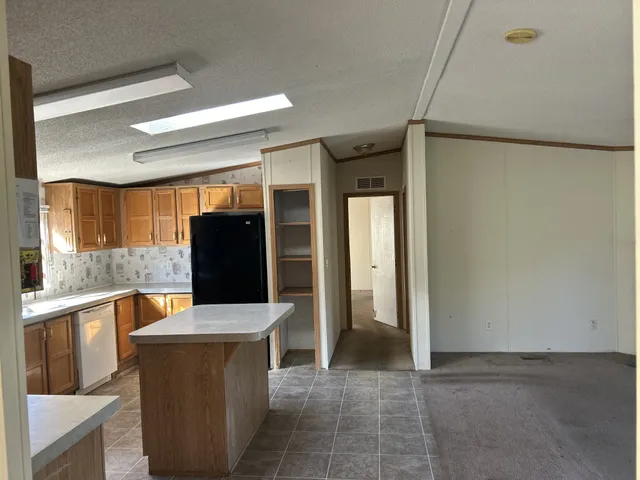 a kitchen with stainless steel appliances granite countertop a stove a sink dishwasher a refrigerator and a microwave oven