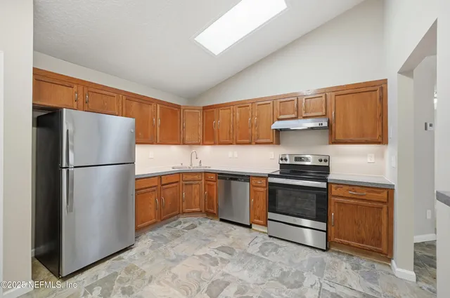 a kitchen with a refrigerator sink and stove
