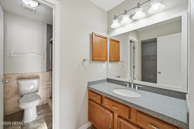 a bathroom with a granite countertop sink toilet and shower