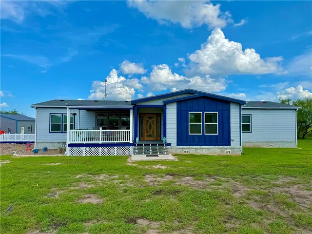 a view of a house with a yard and sitting area