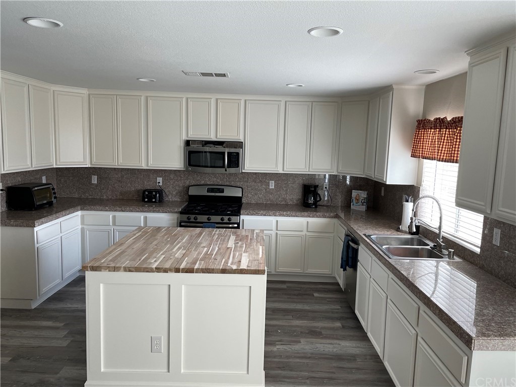 23571 Fallen Boulder Road Menifee, CA 92587 - Photo 13 of 33 a kitchen with sink a stove and cabinets