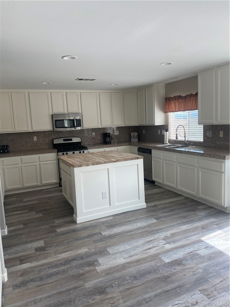 23571 Fallen Boulder Road Menifee, CA 92587 - Photo 14 of 33 a kitchen with stainless steel appliances granite countertop a stove a sink and a microwave
