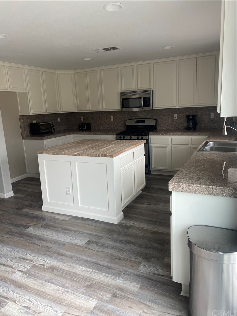 23571 Fallen Boulder Road Menifee, CA 92587 - Photo 15 of 33 a kitchen with granite countertop a sink and a stove top oven