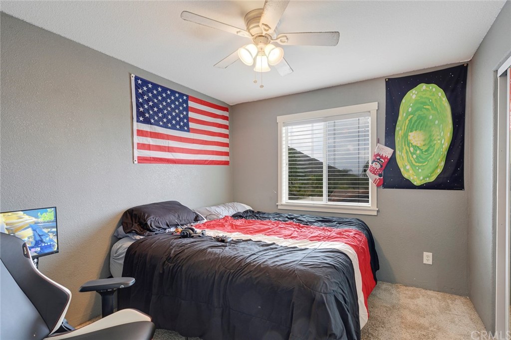 23571 Fallen Boulder Road Menifee, CA 92587 - Photo 25 of 33 a bedroom with a bed and a chandelier