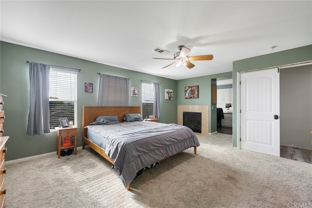 23571 Fallen Boulder Road Menifee, CA 92587 - Photo 28 of 33 a spacious bedroom with a bed and a chandelier