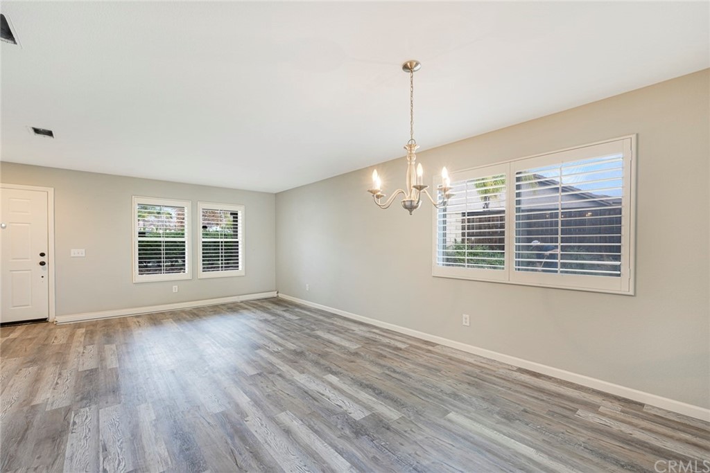 23571 Fallen Boulder Road Menifee, CA 92587 - Photo 10 of 33 a view of an empty room with wooden floor and a window