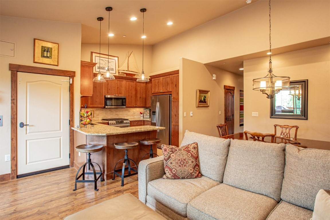 421 Rainbow Drive, Unit 5 Silverthorne, CO 80498 - Photo 14 of 36 a living room with stainless steel appliances kitchen island granite countertop furniture and a wooden floor